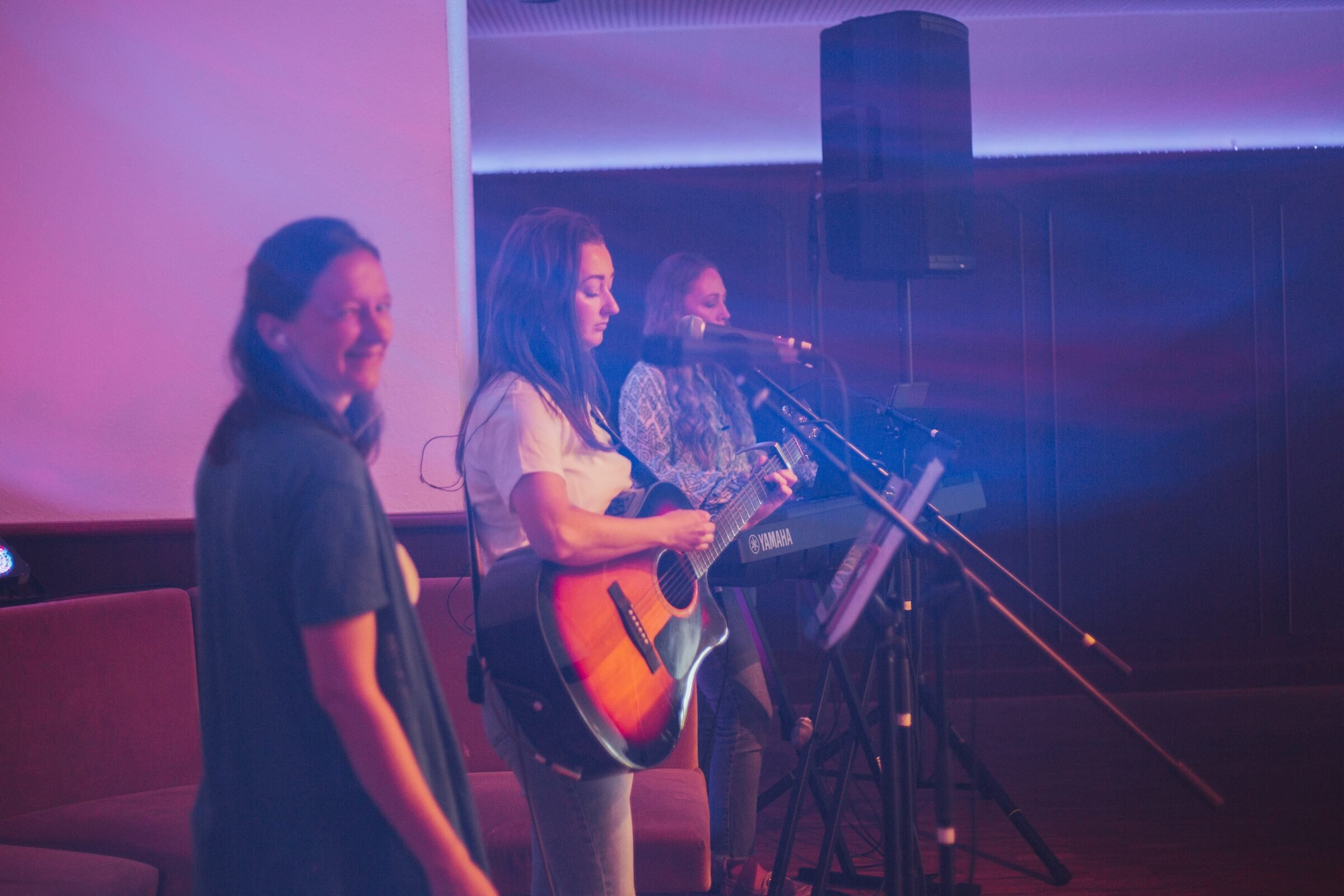 Die Band spielt mit Gitarre im violetten Bühnenlicht